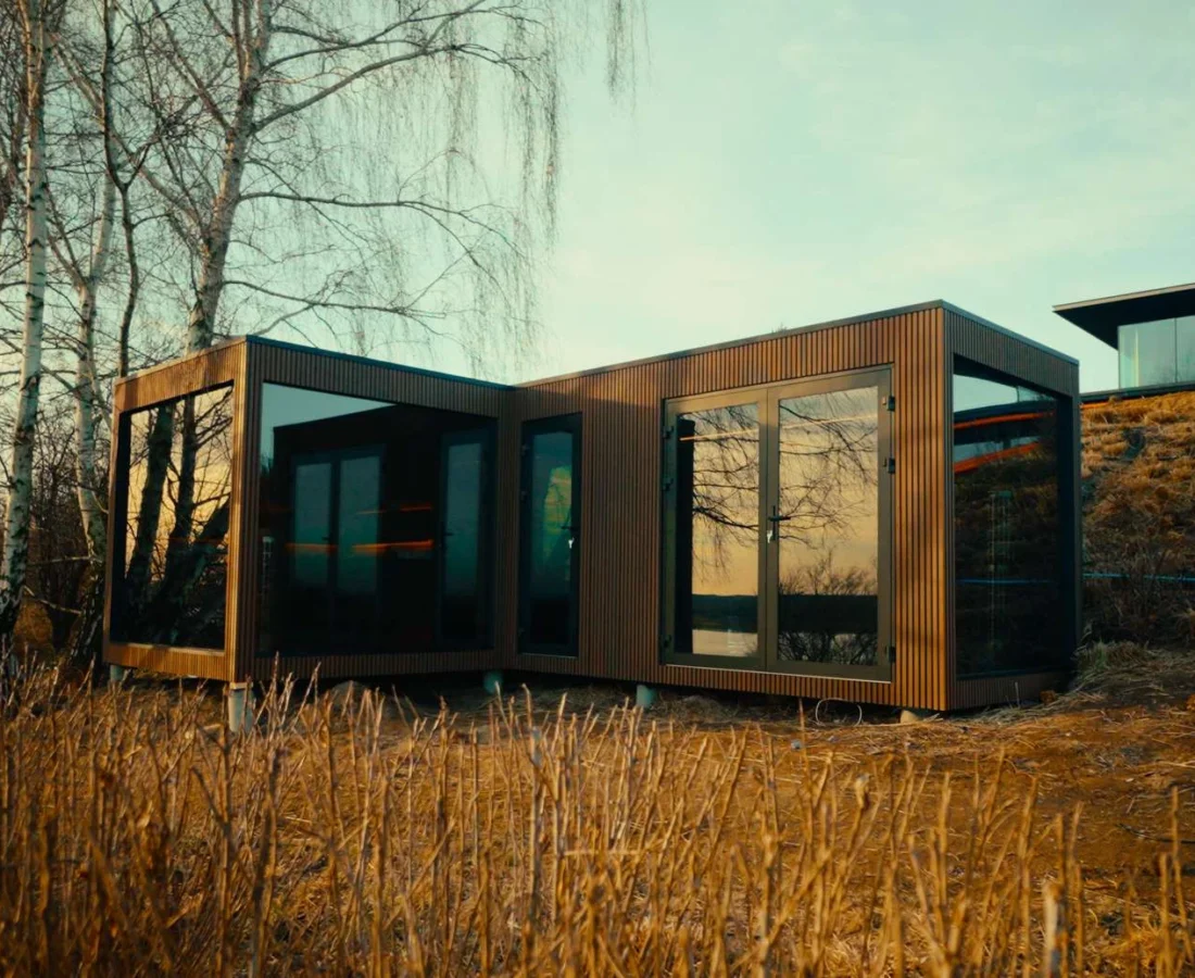 Designerska sauna ogrodowa Luna w kształcie litery L z dużym, zamkniętym przedsionkiem i aluminiowymi drzwiami.
