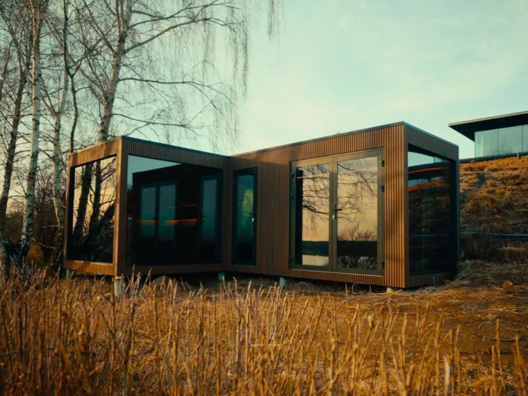 Designerska sauna ogrodowa Luna w kształcie litery L z dużym, zamkniętym przedsionkiem i aluminiowymi drzwiami.